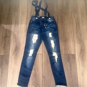Distressed skinny jeans with detachable suspenders.